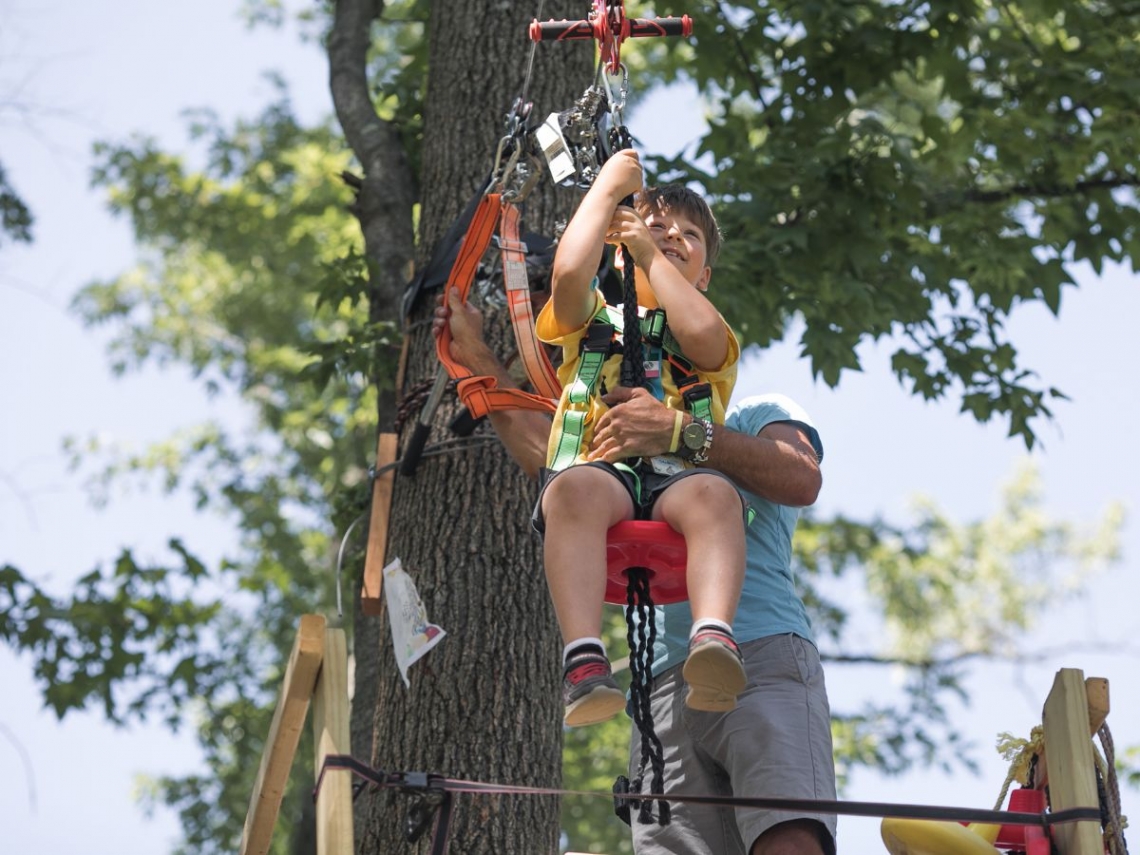 a father helping his son on a backyard zipline.jpg